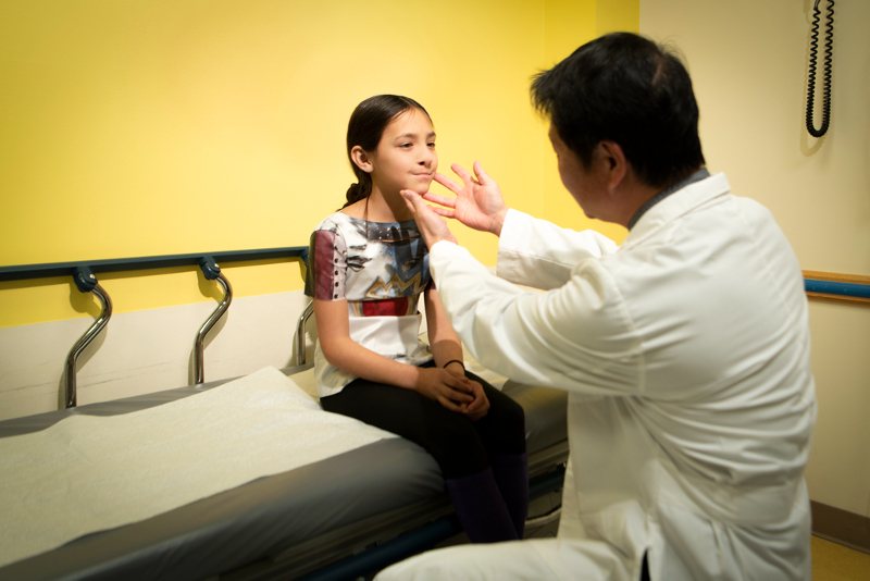 A doctor examines a girl's face