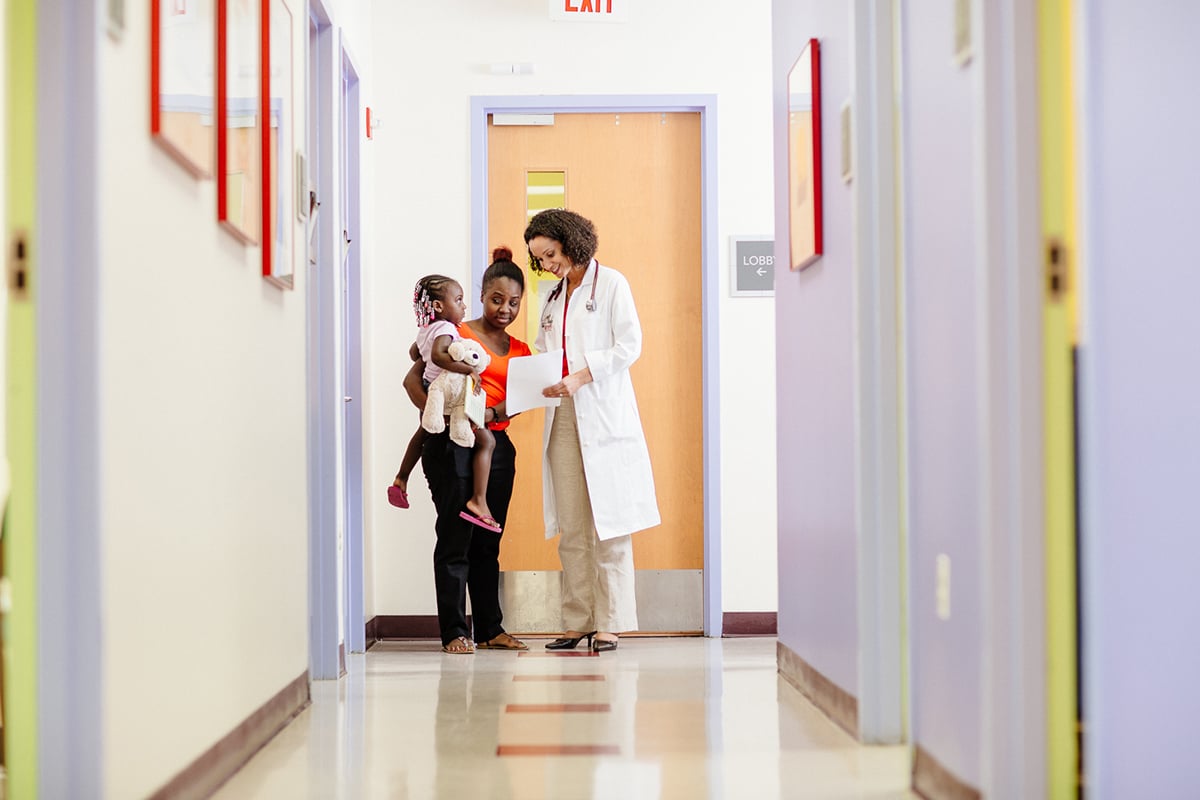 Provider with Family in hospital hallway.