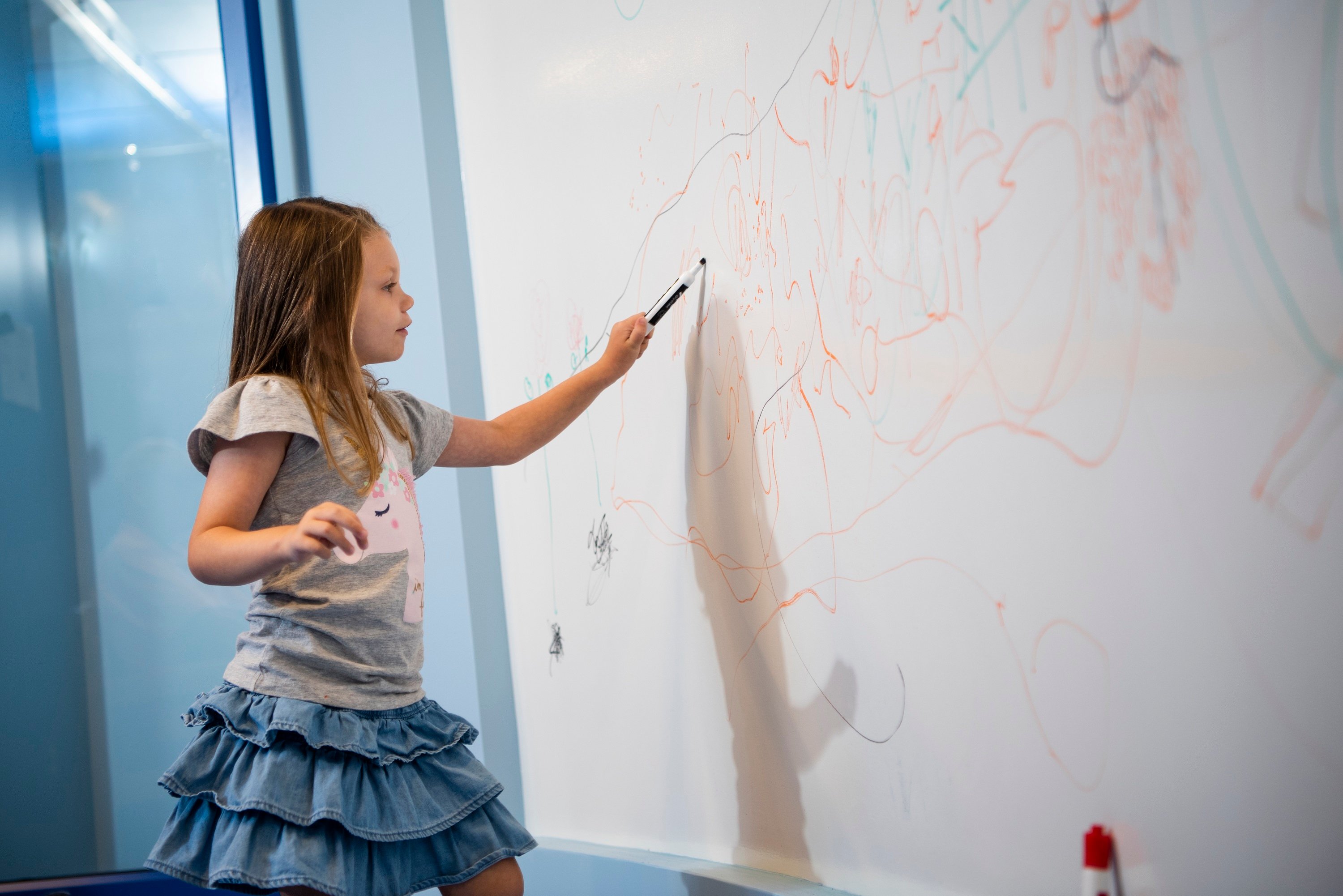 Girl drawing on a whiteboard