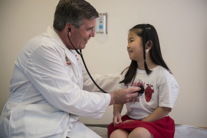 Doctor checking young patient's heart
