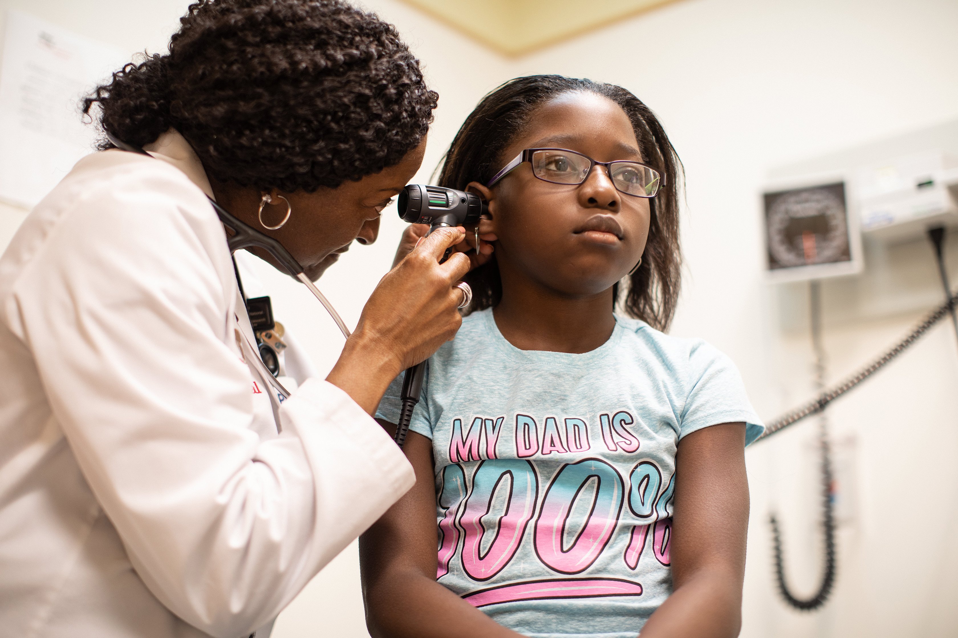 Hematology provider checking ears of patient.