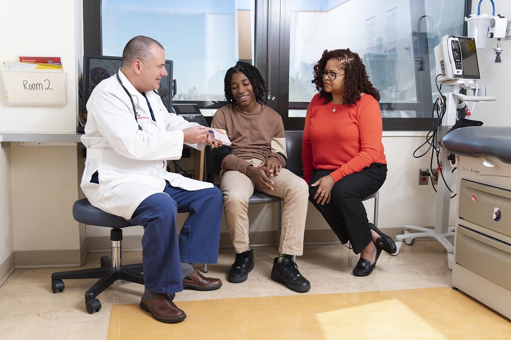 Michael Tsifansky, M.D., director of the Advanced Lung Disease Program at Children's National Hospital, discusses a treatment plan with a teen patient and his mother.