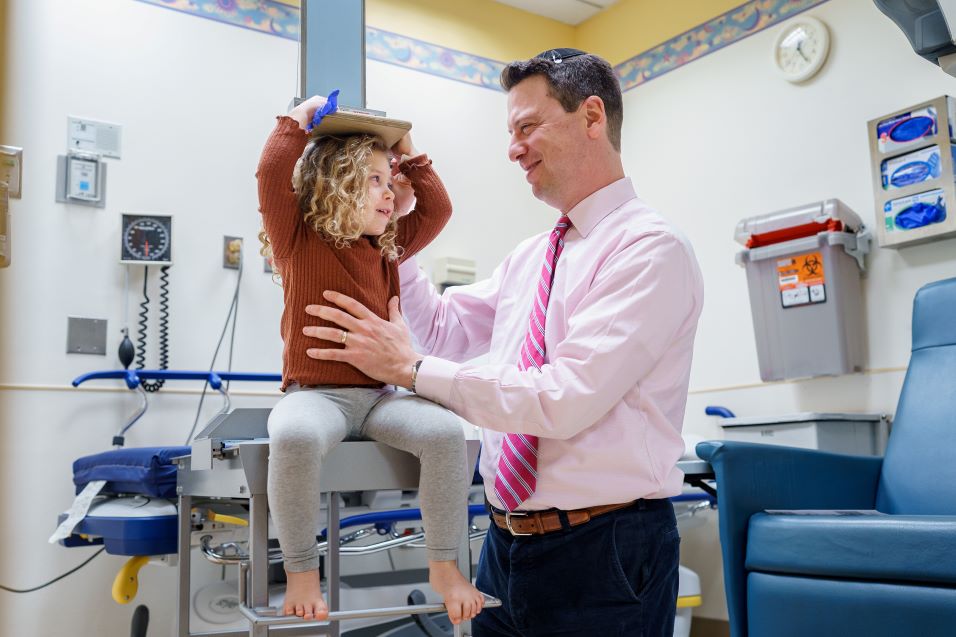 Photo of Dr. Andrew Dauber measuring a patient's growth