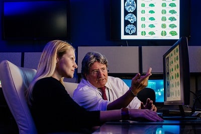 Doctors examine test results on a computer screen