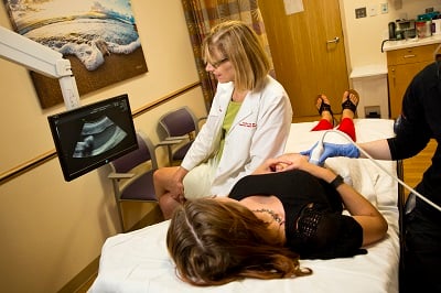 An expectant mother watches the screen as she undergoes an ultrasound test