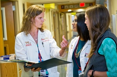 Doctor with medical students chatting in a hallway