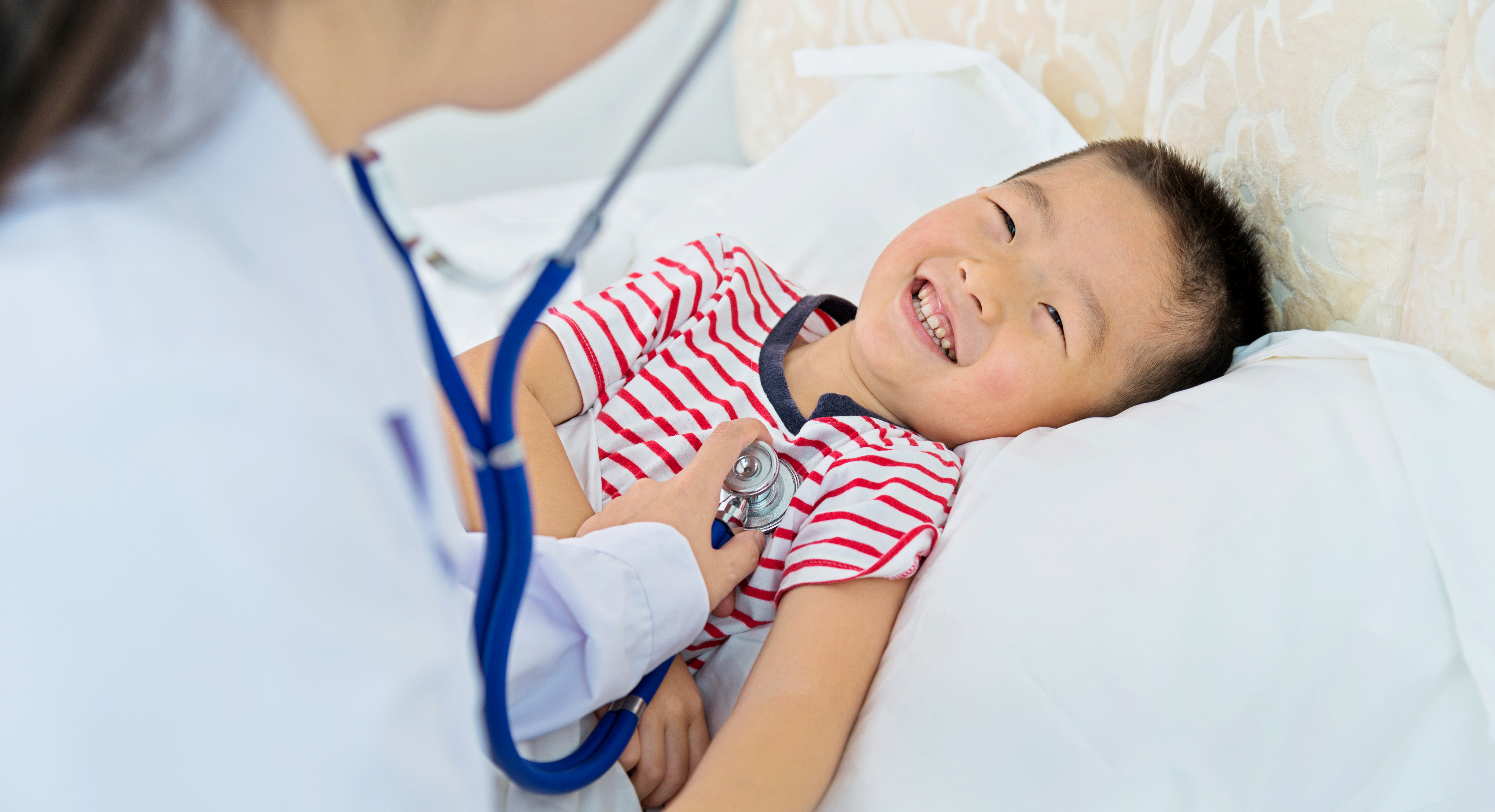 Doctor checks heart rate of smiling patient.