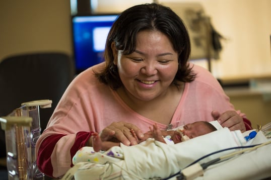 Mother caring for premature baby in NICU