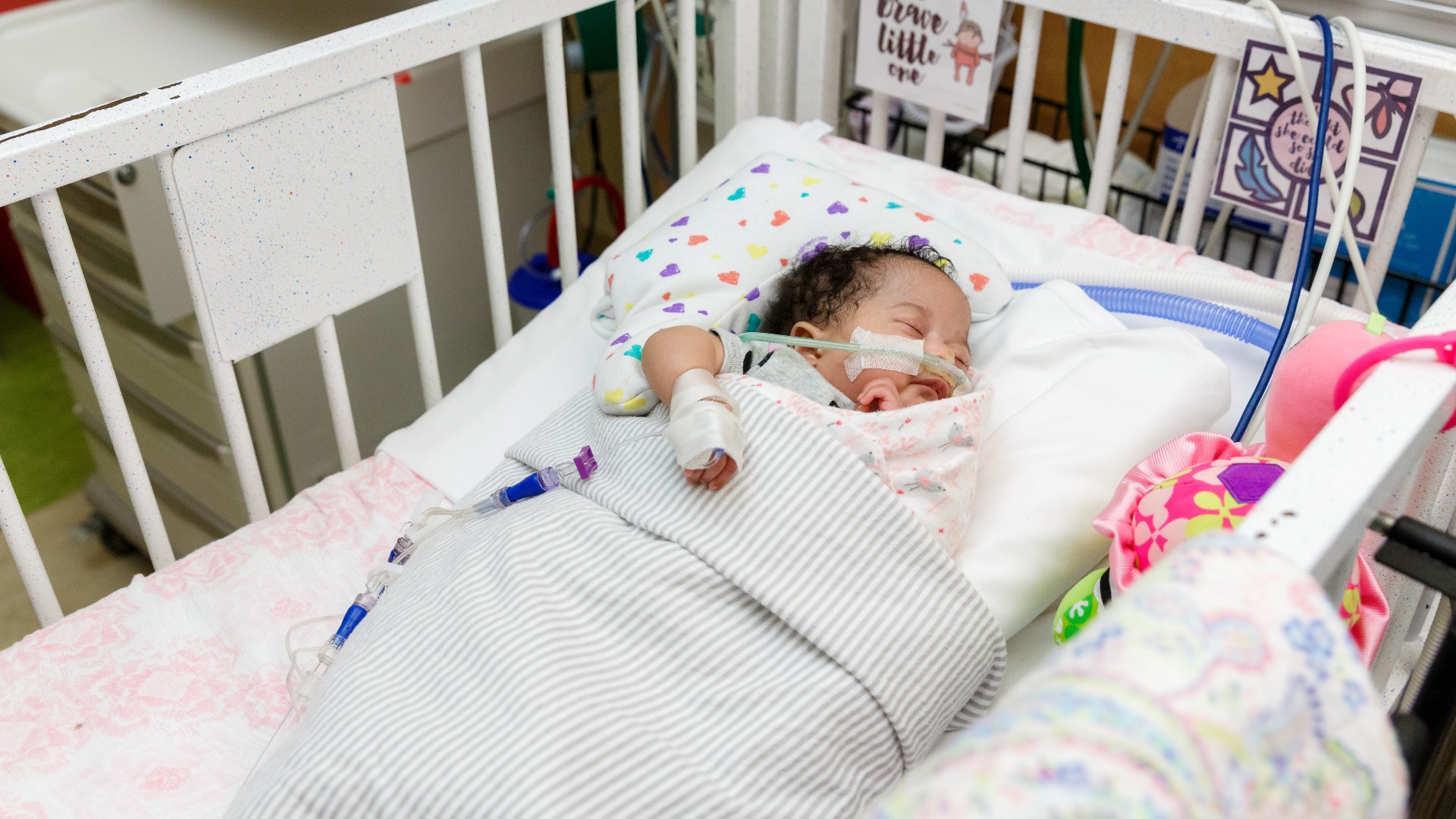 Young baby sleeping in NICU bed