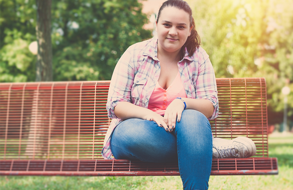 teenage girl sitting on park bench