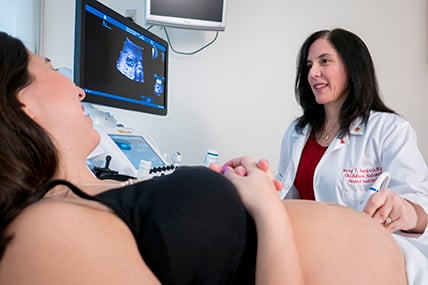 Mujer embarazada siendo examinada por el médico. | Mary Donofrio, M.D., Cardiology, Director of Fetal Heart Program and Amanda Fulgium, Echocardiographer, Cardiology perform a fetal echocardiogram on Fernanda Vessio, Director of Volunteer Services