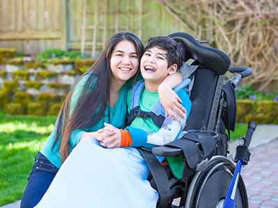 girl hugging boy in wheelchair