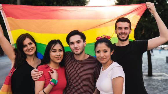 Group of teens holding a rainbow flag