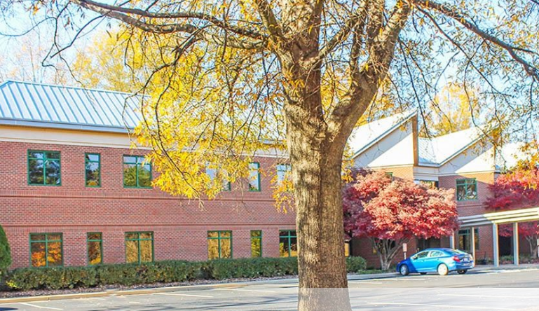 a tree in front of the Cardiology Richmond Chippenham building with the building entrance in the background