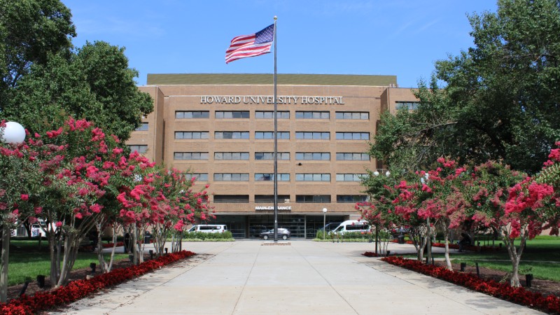 Howard University Hospital with flowering trees lining the road to the entrance