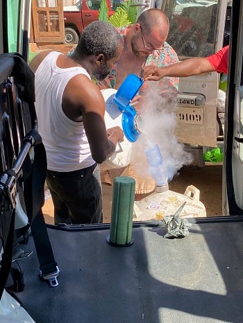 Two men pour liquid nitrogen into the tank containing research samples en route to Kinshasa from Kahemba. 