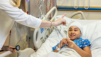 Young boy with head bandage in hospital bed