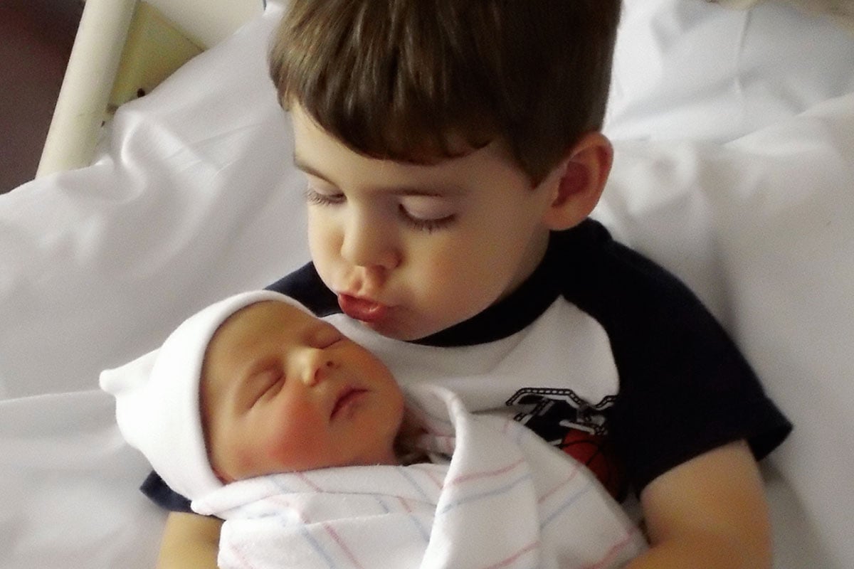Big brother holding his new baby sister
