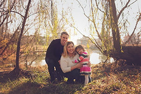 Brynleigh with her parents posing by lake
