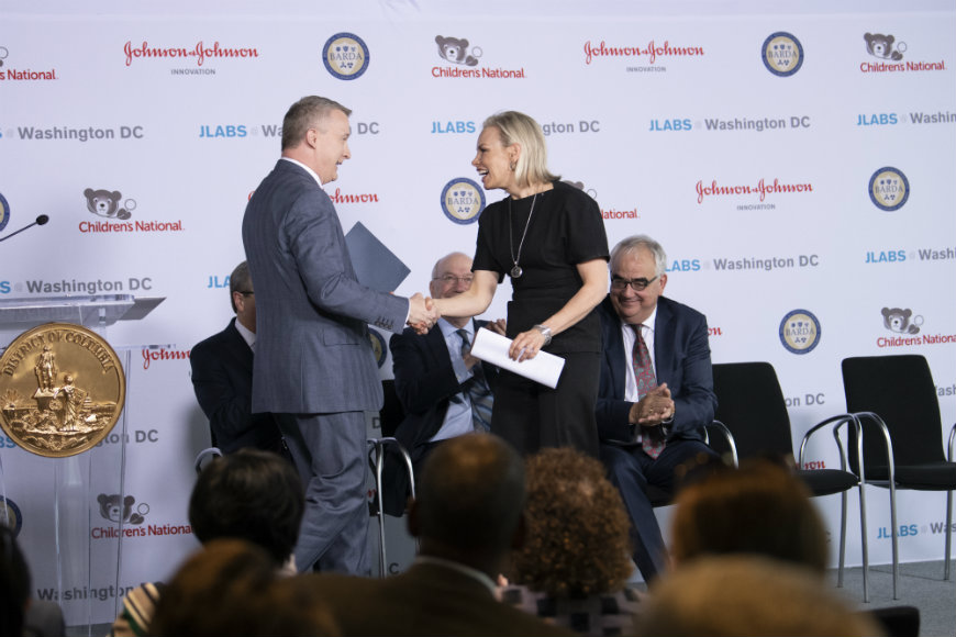 Melinda Richter, Global Head of Johnson & Johnson Innovation – JLABS, shakes hands with gentleman as he crosses stage.