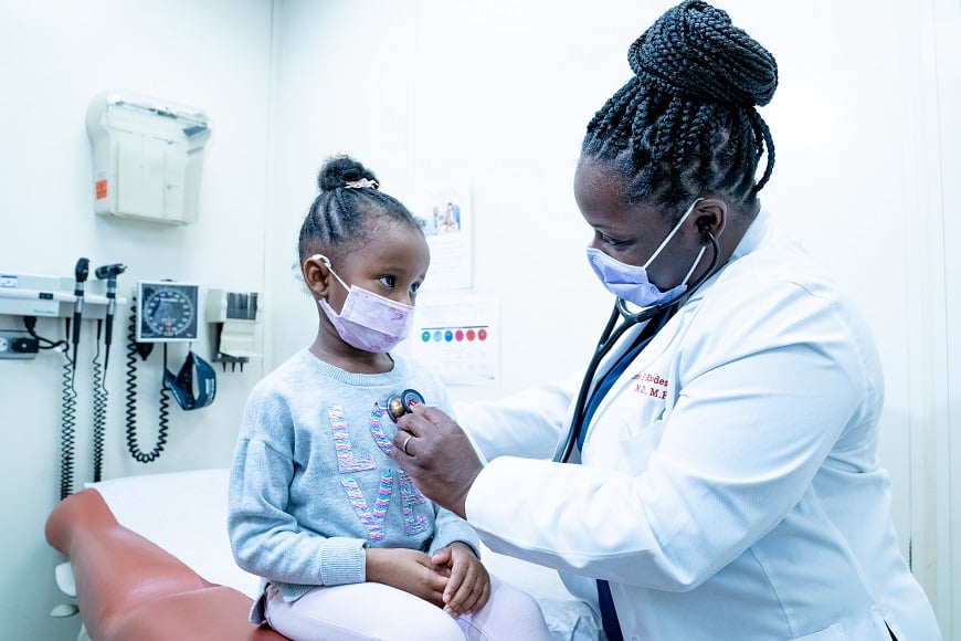 A doctor listen to a young girl's heart in the mobile health van.