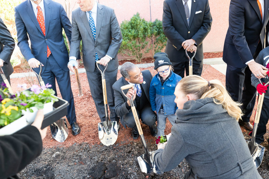 Ward 4 Councilman Brandon Todd and child attendee plant seeds together at groundbreaking ceremony.