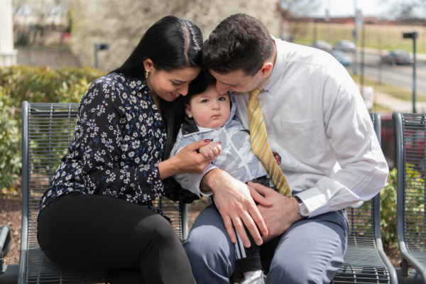 Mom and dad cuddle with baby boy