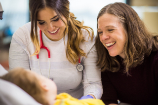 Mother and doctor smiling at baby
