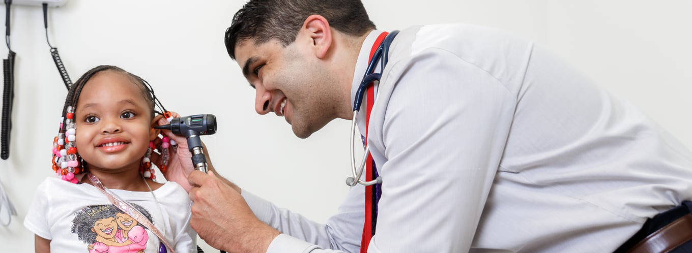 Provider checking young girl's ear