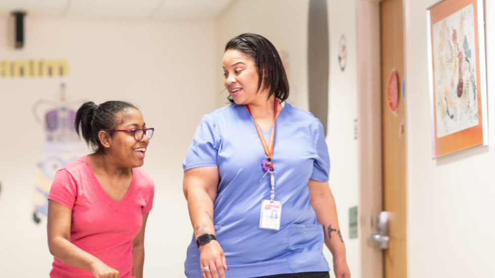 adolescent girl and provider walking down the hallway