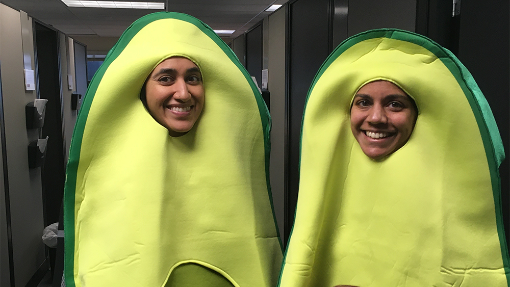 Two people smiling in avocado costumes