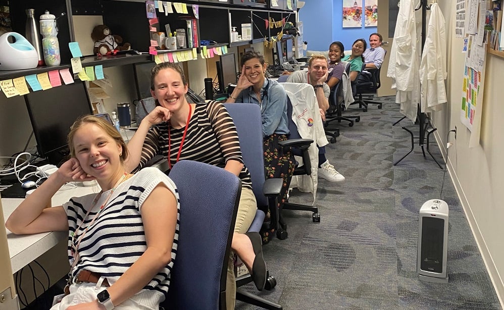 Fellows sitting at their desks in the office