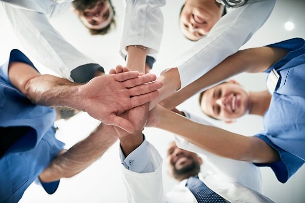 A group of doctors and nurses doing a hand pile