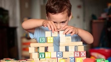 Young boy playing with alphabet blocks