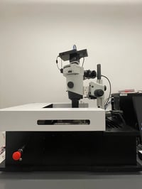 White and black episcopic microscope. Red, circular stop button.