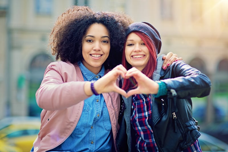 Two girls making heart symbol with their hands