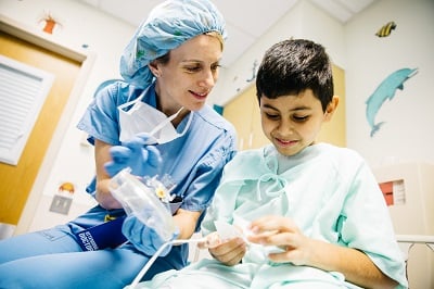 An anesthesiologist shows a patient the mask he'll use when she administers anesthesia ahead of his surgery.