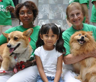 Two women sitting with a child and two dogs