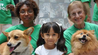 Two women sitting with a child and two dogs