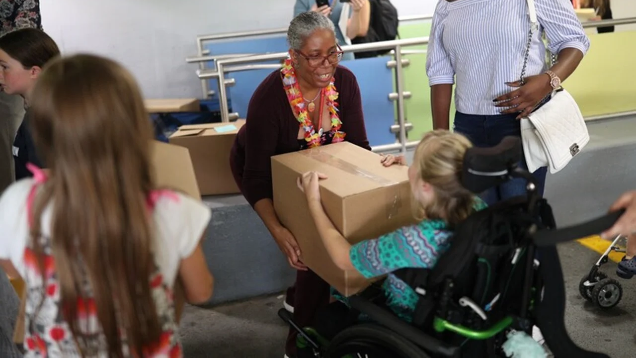 Woman and girl in wheel chair holding a box