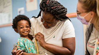 Mother and son with provider using stethescope