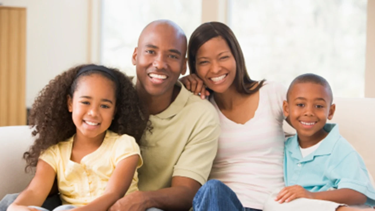 Family sitting on couch smiling