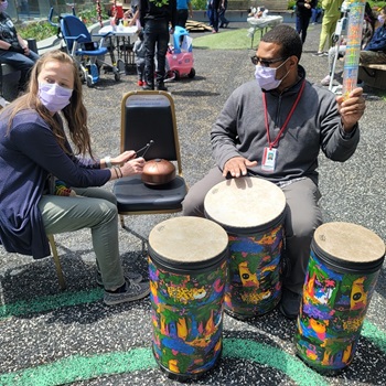 Healthcare providers lead activities in the drum circle in the Healing Garden