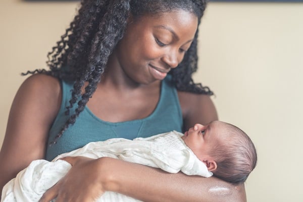 A new mom cradles her newborn daughter in her arms