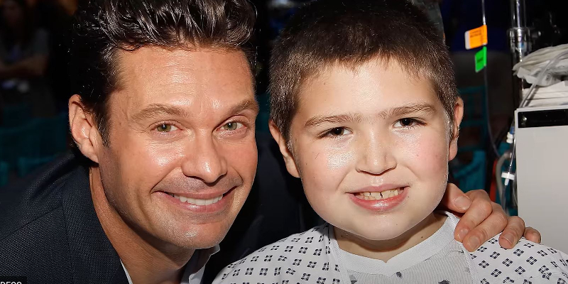 Ryan Seacrest and a little boy smiling for a photo