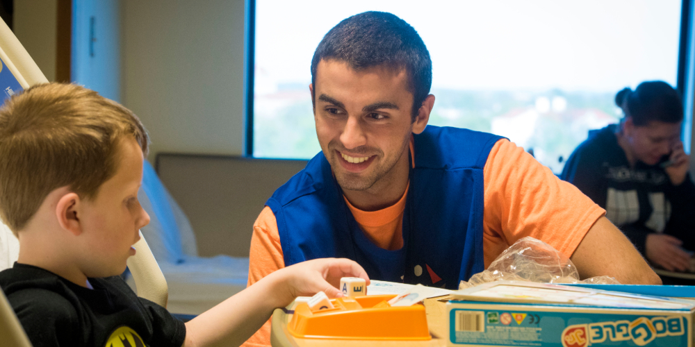 Volunteer playing board game with child