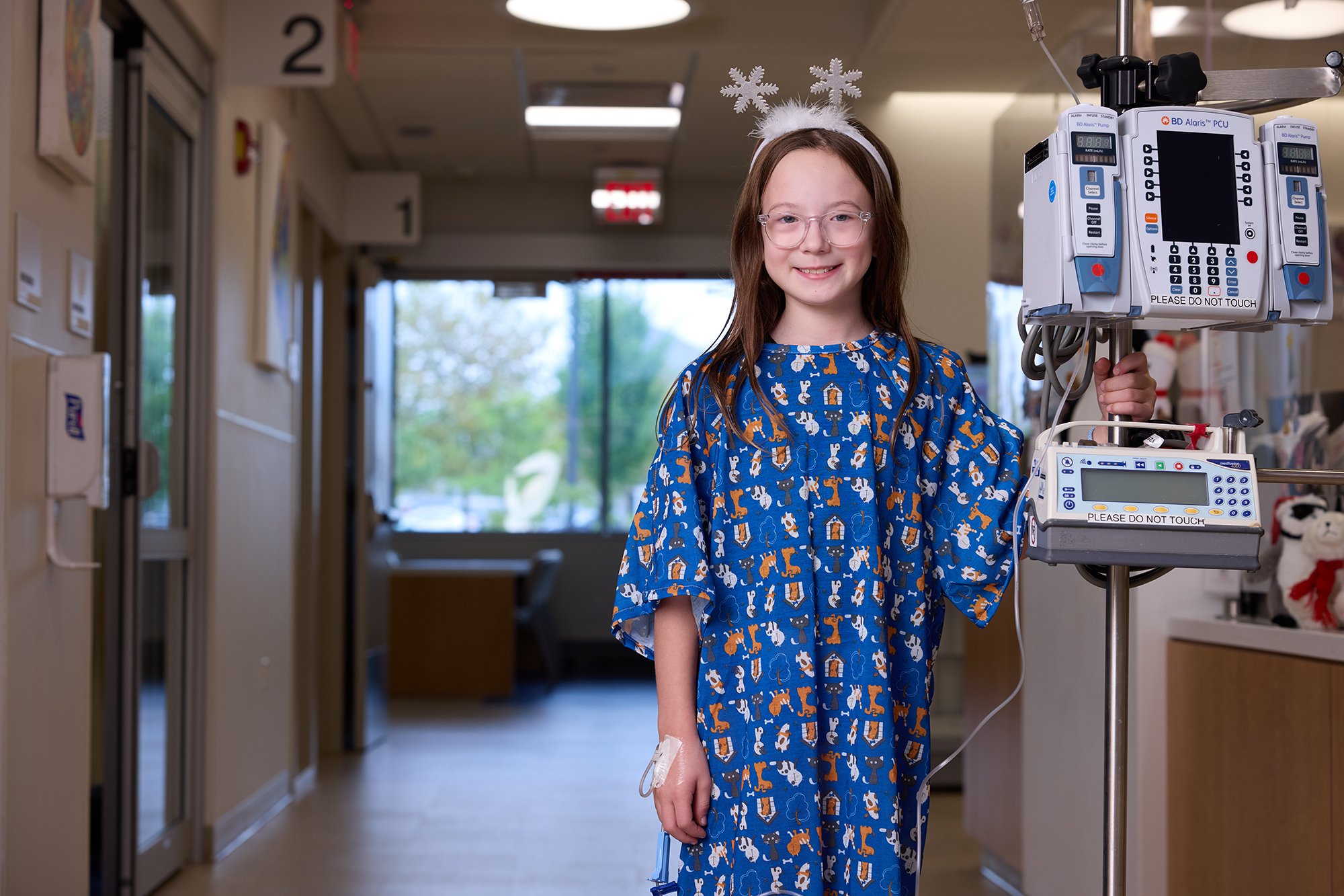 CNH patient McKenzie, age 9, smiles at the camera while wearing a snowflake headband.