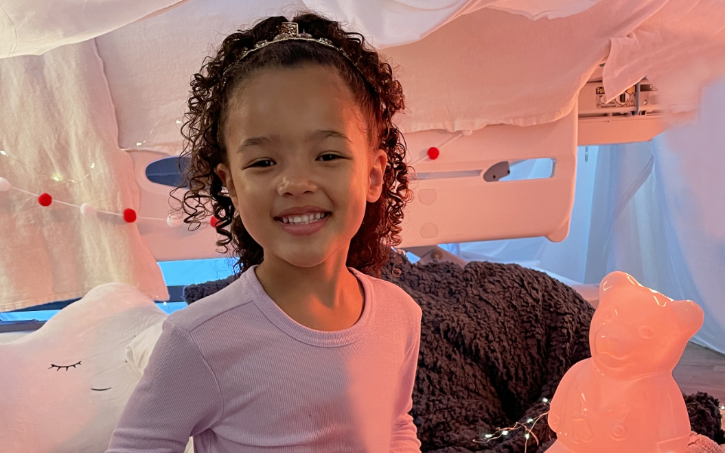 Morgan, a Children's National patient, smiles in the glow of Light Up Dr. Bear