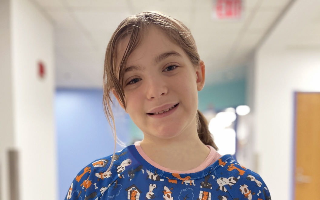Sophia, a Children's National patient, smiles in a hospital hallway