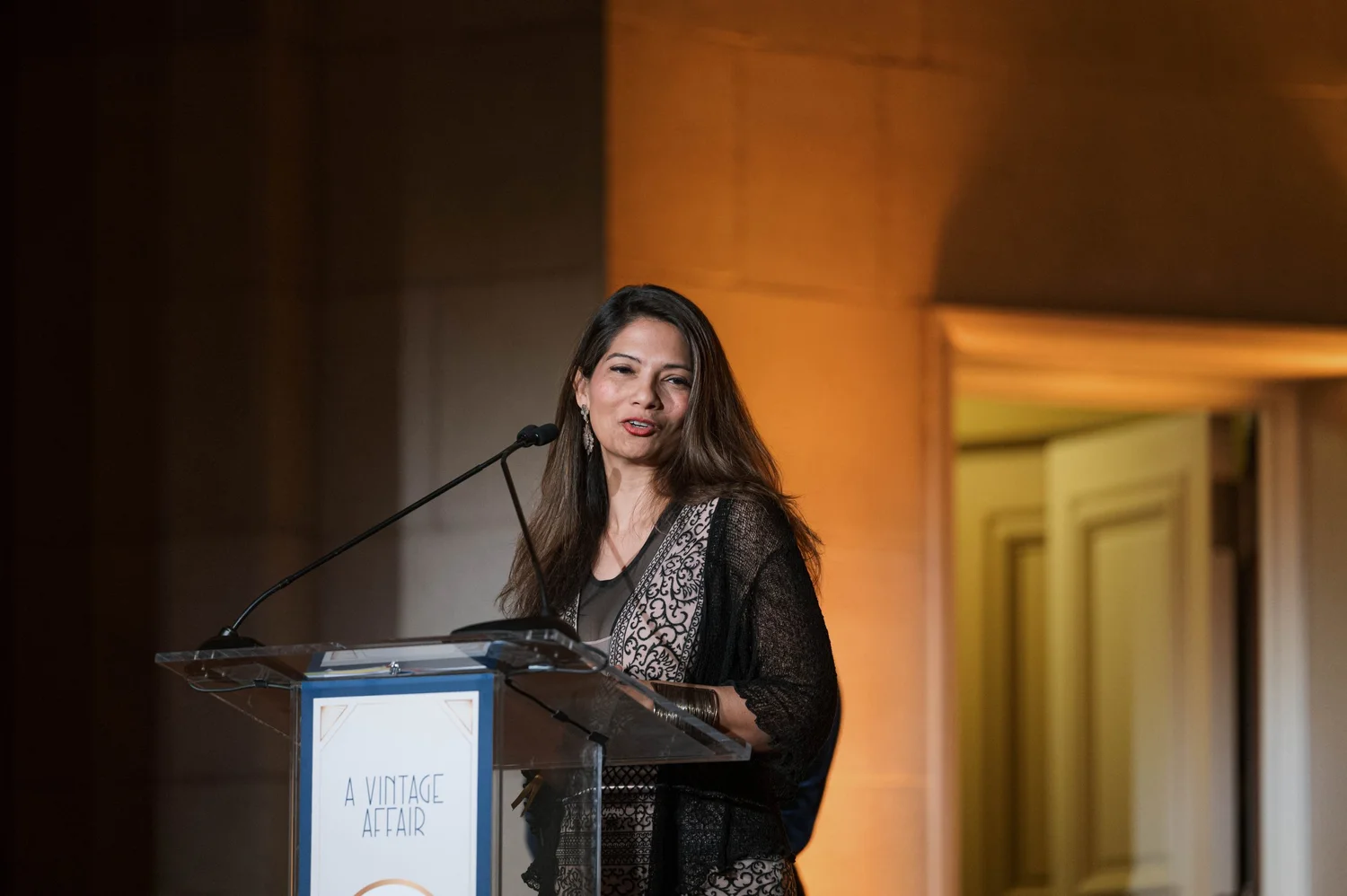 A member of the Founders Auxiliary addresses guests from a podium during the A Vintage Affair 2025 event at the Mellon Auditorium in Washington, D.C.